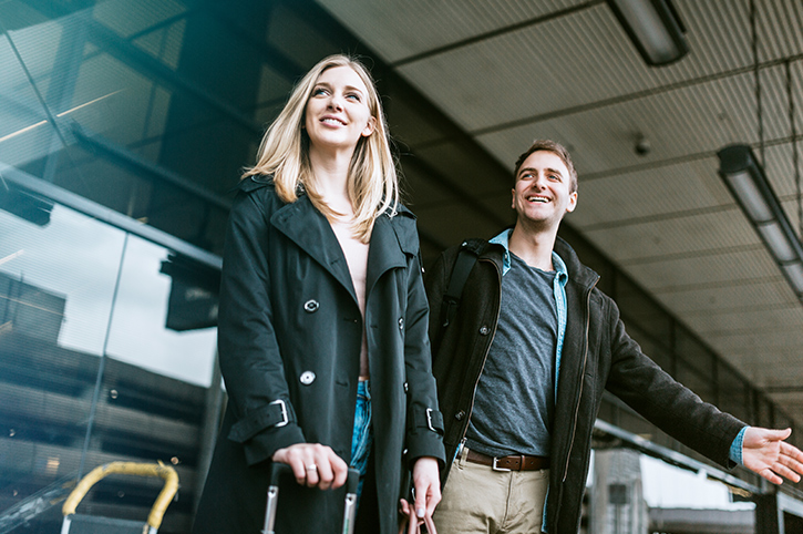 Couple hailing a taxi at arrivals at the airport