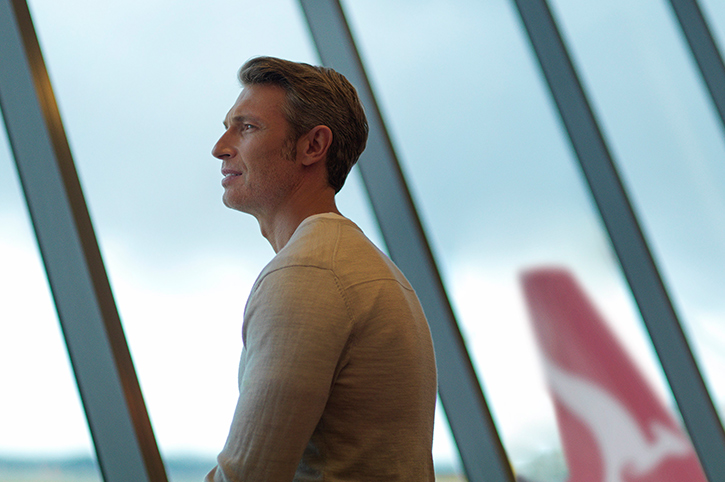 Man at airport, boarding on Qantas flight