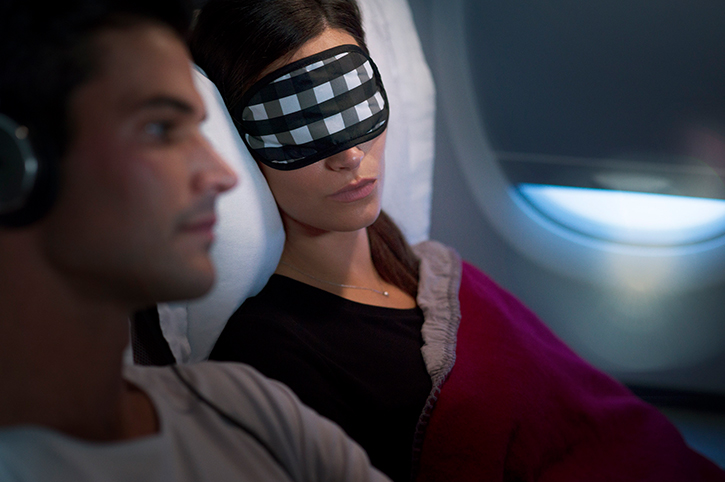Lady with an eyemask sleeping on a plane
